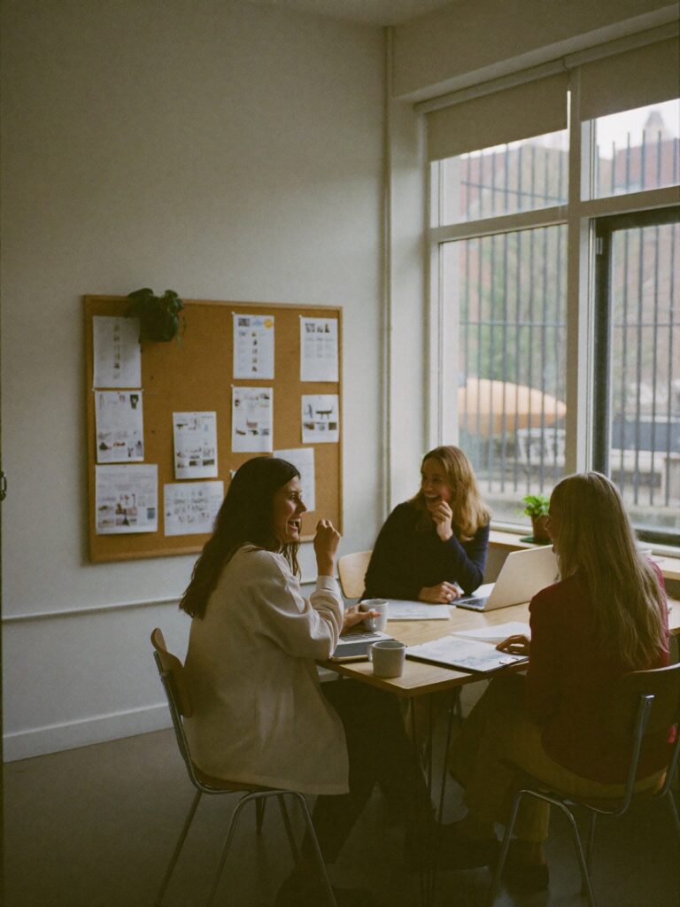 Collega's van een makelaarskantoor lachen samen aan tafel